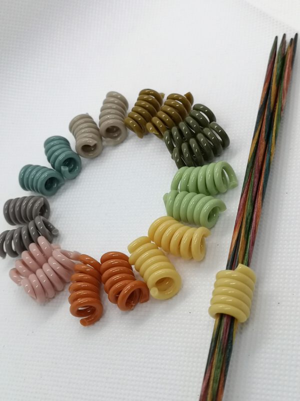 Nadelhalter Nadelspiel Spirale in klassischen Farben, Farbkreis und ein gelber auf einem Nadelspiel